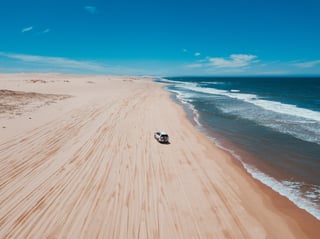 Samochód terenowy na plaży z falami